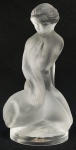 LALIQUE  LEDA E O CISNE  COM MARCAS DA MANUFATURA E ETIQUETA. LINDA ESCULTURA EM VIDRO ARTÍSTICO SATINE APRESENTANDO OS PERSONAGENS MÍTICOS LEDA E O CISNE. LEDA É APRESENTADA DESNUDA TENDO O CISNE ENLAÇADO EM SEU BRAÇO. FRANÇA, SEC. XX. 12 CM DE ALTURANOTA: Leda era uma jovem e bela princesa, recém-casada com Tíndaro, herdeiro do reino de Esparta. Gostava de deitar-se na relva, apreciando o canto dos pássaros e expunha seu corpo aos raios do sol, sob olhares indiscretos dos deuses. Certa vez, Zeus ia a caminho da cidade de Tróia e encontrou Leda deitada seminua na relva e parou para contemplá-la de longe. Temendo assustá-la com sua figura gloriosa e resplandecente, Zeus converte-se em um cisne imenso e de bela plumagem para poder cortejar a princesa. O deus supremo temia também que, por ser a bela princesa recém-casada, provavelmente o repeliria. Ao ver o belo cisne se aproximando, Leda senta-se e começa a observá-lo. Diante dos olhos da princesa, o cisne começa a mover suas belas plumas com grande excitação, movimenta seu corpo em uma dança de vai e vem que mostra seu desejo e soa sua voz delicada, emitindo sinais de atração e paixão. Leda estava fascinada e o cisne aproximou-se mais e começou a tocá-la e acariciá-la com suas plumas e seu longo pescoço. Excitada, Leda deitou-se novamente na relva e aguardou que o cisne se deitasse sobre ela, e então se amaram. Meses depois a princesa sente fortes dores e percebe que de seu ventre haviam saído dois ovos: do primeiro, nascem Castor e Helena, do segundo, Pólux e Clitemnestra. Porém Hera, esposa de Zeus, com ciúmes, persegue e proíbe Leda de viver no reino. Assim, Zeus compensa Leda, convertendo-a em deusa e reservando-lhe um espaço no céu, na forma de uma estrela na constelação de Cisne. Os filhos de Leda e Zeus, Castor e Pólux, tornam-se grandes guerreiros e amigos inseparáveis. Porém Castor (que herdou a mortalidade humana) perde a vida em uma batalha e Pólux (que herdou a imortalidade divina) suplica a Zeus que devolva a vida do irmão. Comovido com esta demonstração de amor fraterno, Zeus propõe a Pólux dividir sua imortalidade, alternando com o irmão um dia de vida e um dia de morte. Assim os irmãos passaram a viver e a morrer alternadamente e Zeus os homenageia com a constelação de Gêmeos, pela qual não poderiam ser separados nem com a morte.