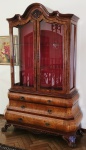 SUNTUOSA VITRINE ESTIL0 BARROCO EM MADEIRA REVESTIDA DE RÁDICA. FORNITURE HOLANDESA. FORMA CONJUNTO COM A CÔMODA APREGOADA NO LOTE ANTERIOR. ESSE MAGNIFICO MÓVEL EXPOSITOR É DOTADO DE TRÊS GAVETAS SOBREPOSTAS E BELISSIMO NICHO EXPOSITOR REVSTIDO EM TECIDO VERMELHO. FINALIZA SOBRE PÉS COM CAPRICHADAS GARRAS. ESTÁ EM ÓTIMO ESTADO.  215 X 120 X 43