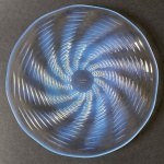 RENNE LALIQUE - PRATO ONDES - FORMIDÁVEL PRATO EM VIDRO OPALESCENTE DE RENNE LALIQUE MODELO ONDES.REFERENCIA 10-3035 INTRODUZIDO EM  1935.  O PADRÃO EM ONDAS FORMA BELISSIMO TURBILHÃO. ASSINADO PELO ARTISTA. FRANÇA, DEC. 30. 28 CM DE DIAMETRO