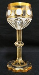 IMPÉRIO AUSTRO HUNGARO - MOSER - LINDO GOBLET EM CRISTAL DECORADO COM ESMALTES E OURO. PÉ COM FEITIO DE FLOR. FUSTE FACETADO. BOJO COM BASTILHADO OCTAGONAL EM ESMALTE BRANCO EMOLDURADO EM OURO. PEÇA MAGNIFICA PARA COLECIONADOR! IMPERIO AUSTRO HUNGARO, SEC. XIX. 21 CM DE ALTURA