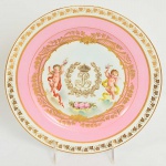 SEVRES - REI LOUIS PHILIPPE  AVO DO CONDE DEU  RARO PRATO EM PORCELANA CHATEAU DE TULLERIES COM BORDA DECORADA COM PARRAS EM OURO DELIMITADAS POR UM FRISO TAMBÉM EM OURO SUCEDIDO POR BARRADO ROSE. RESERVA COM QUERUBINSENTRE LAUREU COM AS INICIAIS DO MONARCA SOB COROA REAL. DATADOS DE 1844. FRANÇA, SEC. XIX. 23 CM DE DIAMETRONOTA: Este serviço foi encomendado pelo rei Louis Philippe em 1836: as primeiras peças foram entregues em 1839 e as últimas em 1847. Selos da fábrica de Sèvres e do Palácio de Fontainebleau (em vermelho). Partes deste serviço são mantidos no Chateau de Fontainebleau e no Metropolitan Museum of Art, em Nova York. Louis Philippe detém a distinção única de ser o último Rei da França. Sua vida foi pontuada por intrigas, revolução, poder e exílio através de um dos períodos mais tumultuados e obscuros da história política francesa. Embora de origem nobre, apoio a Revolução Francesa servindo inclusive no exército republicano como General. Com a conturbação do movimento revolucionário, temendo por sua vida impôs a si um exílio nos EUA que perdurou por anos. Mas o destino finalmente começou a sorrir para a família Orléans. Após a abdicação forçada do imperador francês Napoleão Bonaparte em 1815 e a posterior restauração dos Bourbons, Luís Filipe então conhecido como Louis Philippe III, duque de Orléans voltou para a França, seu primo foi coroado Rei Luís XVIII da França. Ao mesmo tempo em que conseguiu conciliar os ramos Orleans e Bourbon da família na corte, Louis Philippe ainda ficou ao lado da oposição liberal. Em julho 1830 uma outra revolução expulsou o rei Carlos X. O Governo francês, em seguida, principalmente por causa de suas crenças liberais e popularidade pública, proclamou Louis Philippe como Rei de França. Seu governo procedeu de forma despretensiosa e evitou a pompa e gastos extravagantes de seus antecessores. Mas durante o seu reinado as condições das classes trabalhadoras e deteriorou a diferença de renda entre ricos e pobres alargou-se consideravelmente. Uma crise econômica em 1847 levou a uma nova revolução em fevereiro o que obrigou Louis Philippe a abdicar e buscar exílio na Inglaterra sob a "proteção" da rainha Victoria. Louis Philippe morreu em Claremont Surrey em 26 de Agosto de 1850. O rei Louis Phillipe era avô do Conde DEu: Luís Filipe Maria Fernando Gastão, conde d'Eu (Louis Philippe Marie Ferdinand Gaston; Neuilly-sur-Seine, 28 de abril de 1842 Oceano Atlântico, 28 de agosto de 1922), foi o conde d'Eu. Gastão renunciou aos seus direitos à linha de sucessão ao trono francês em 1864, quando do seu casamento. Tornou-se príncipe imperial consorte do Brasil por seu casamento com a última princesa imperial de fato, D. Isabel Cristina Leopoldina de Bragança, filha do último imperador do Brasil, Dom Pedro II. Faleceu quando voltava ao Brasil para celebrar o centenário da independência brasileira do Reino Unido de Portugal, Brasil e Algarves, em 1922.