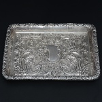 <b>Bandeja para correspondência</b> de forma retangular em prata inglesa. Profusa decoração com angras, volutas e flores em relevo e reserva ao centro. Contraste da cidade de Sheffield de 1903. Prateiro WALKER & HALL. Med. 26,5 x 20 cm. Peso 335 gramas.