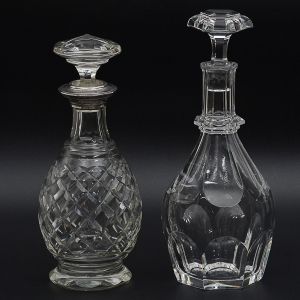Lote constando de: a) <b>Cristallerie BACCARAT - Garrafa</b> bojuda com gargalo alongado em cristal lapidado com marca da cristallerie na base. Alt. 30 cm; b) Antiga <b>garrafa</b> bojuda em cristal europeu, apresentando bocal em prata Sterling 925 ml e lapidação losangular. Alt. 28 cm