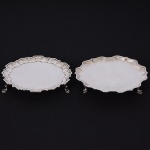 <b>Conjunto de duas pequenas salvas</b> circulares em prata inglesa lisa. Apresentam bordas em recortes com bicos e pés em sapatas. Uma delas com contraste da cidade de Londres de 1906 e marca do prateiro CHARLES STUART HARRIS & Sons Ltd. A outra com contraste de Londres de 1941 e marca do prateiro J. W. & Co. Diâm. 16 e 15 cm. Peso 370 gramas.