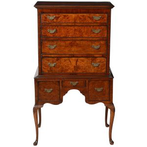 <b>Móvel inglês </b>vitoriano conhecido como "chest on stand", construído em raiz de nogueira. Parte superior com quatro gavetas superpostas encaixadas em base com três gavetas e pequena saia recortada. Pernas recurvadas terminadas sapatas. Puxadores em metal lavrado. Séc. XVIII. Med. 149 x 86 x 54,5 cm