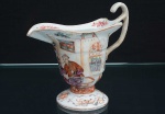 <b>Leiteira </b>dita "helmet shaped jug" em porcelana Companhia das Índias decorada em policromia com figuras de nobres em cena de terraço. Séc. XVIII. Alt. 16 cm