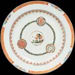 <b>Medalhão</b> circular em porcelana Companhia das Índias, decorado em policromia Família Rosa, tendo ao centro reserva com paisagem cercada de três composições com flores. Aba em pontas de lança e borda em arabescos. Predominância das tonalidades "rouge de fer", verde e ouro. Séc. XVIII. Diâm. 32 cm