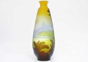 <b>EMILE GALLÉ - Rio de Janeiro - Vaso </b>alongado em "cameo glass" de tonalidades amarelas, azuis e castanho. De um lado decorado com casario da Praia de Botafogo tendo ao fundo o Corcovado e na outra face, iconografia de São Conrado. Exuberante decoração tropical completa o conjunto. Assinado e localizado Rio de Janeiro. Alt. 46 cm