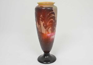 <b>EMILE GALLÉ - Rio de Janeiro. Vaso</b> alongado de bocal raso, levemente revirado com base circular em "cameo glass" de tonalidades amarela, vermelha e castanho. Decoração com topografia de São Conrado, o mar e figuras de aves entre exuberante vegetação tropical. Ass. Alt. 43,5 cm