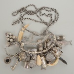 Belíssima e antiga <B>penca</b> baiana em prata com inúmeros adereços de sorte e candomblé. Cadeado lavrado ladeado por pássaros tropicais. Corrente de época. Largura do cadeado 16 cm. Peso 1100 gramas.