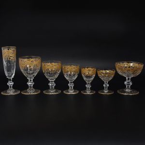 <b>Serviço de copos</b> francês em cristal Saint Louis belamente lavrado a ouro com estilizações vegetais e base com frisos. Constando de 10 flutes, 16 taças de champanhe, 10 taças p/ água, 18 taças p/ vinho, 11 copos p/ suco em dois tamanhos, 34 taças em três tamanhos pequenos,  para vinho do Porto e licor e 6 copos para whisky. Marca da Cristallerie no verso. Total 105 de peças.