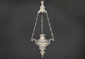 <b>Lampadário </b>em prata brasileira repuxada e cinzelada, decorada com guirlandas, rosetas e folhas de palmas, em delicadas composições. Correntes originais belamente vazadas. Contraste da Bahia e marca de prateiro. Séc. XVIII. Alt. 120 cm