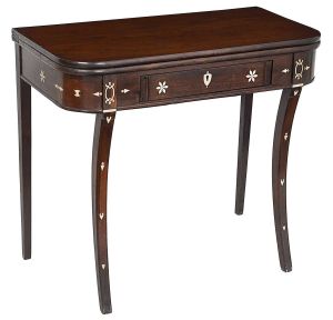 Rara <b>mesa de encostar</b> portuguesa D. Maria I, em madeira nobre, reversível para mesa de jogos, apresentando cantos arredondados, gaveta central e pernas recurvadas para dentro. Bela "marqueterie" em marfim com rosetas, elementos ovais e outros pequenos inusitados. Início do séc. XIX. Med. 80 x 91 x 45 cm