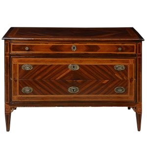 <b>Cômoda</b> italiana do séc. XVIII construída em vários cortes e tonalidade de nogueira. Caixa retangular com três gavetões e decoração em "marqueterie" com frisos e rosetas aos cantos. Pés afilados para baixo. Puxadores e espelhos das fechaduras metálicos. Med. 88 x 123 x 57 cm