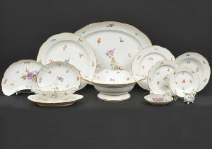 Belíssimo e extenso <b>serviço de jantar</b> em porcelana alemã de Meissen decorada em policromia com salpicados de flores e bordas em treliças. Realces em filetes dourados. Séc. XIX. Marca da manufatura no verso. Constando de 50 pratos rasos, 22 pratos de sopa, 18 pratos de sobremesa, 22 pratos de pão, 1 sopeira encimada por figura infantil com cornucópia de frutos, 9 travessas ovais de vários tamanhos, 2 legumeiras circulares, 1 travessa circular, 2 "bowls" quadrangulares, 3 covilhetes ovais, 2 covilhetes meia lua, 2 molheiras com base, 2 pequenas cremeiras, 12 xícaras de chá com pires com ligeira variação de decoração com flores e insetos. Total de 148 peças.
