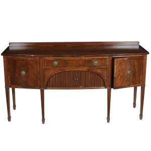 <b>"Sideboard" inglês </b>vitoriano construído em mogno. Caixa retangular levemente abaulada à frente apresentando duas portas laterais centralizando gavetão e armário com portas em esteirinha. Pernas retilíneas levemente afiladas e frisos em baixo relevo. Ferragens de época modeladas em rosetas e perolados. Séc. XIX. Med. 92 x 184 x 63 cm