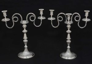 <b>Par de candelabros para três velas</b> cada em prata portuguesa no estilo neoclássico. Braços em serpentinas frisadas e bordas com pequenos perolados. Hastes em forma de balaústre decoradas em gomos e guilhochados. Base esférica com dois filetes também perolados. Contraste da cidade de Lisboa do final do séc. XVIII. Marca de dois prateiros sendo um de ALBERTO LUIS BION e outro não identificado. Alt. 44 cm