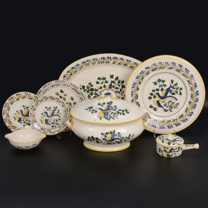 <b>Serviço para jantar ou feijoada</b> em cerâmica decorada em policromia com pássaros e estilizações predominando tonalidades de azul, amarelo e verde. Marca da manufatura Luiz Salvador - Itaipava no verso. Constando de 12 pratos rasos, 12 pratos de sobremesa, 8 pratos p/ petiscos, 1 grande sopeira, 1 pequena terrina p/ molho c/ "presentoir", 1 travessa funda oval, 1 panelinha c/ tampa, 4 cumbucas circulares, 1 grande travessa oval, 1 grande travessa circular. Total de 43 peças. Compr. da sopeira 38 cm; Compr. da travessa oval 50 cm; Diâm. da travessa circular 36 cm