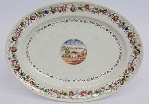 <b>José Pinheiro Freire. Travessa oval</b> em porcelana Companhia das Índias do serviço conhecido como "Paquetá". José Pinheiro Freire foi médico na Bahia e posteriormente no Rio de Janeiro e residia na Ilha de Paquetá, na Baia de Guanabara. Reserva ao centro onde acredita-se que a paisagem seja da Ilha de Paquetá. Borda tipicamente portuguesa com flores, folhas de parreira e cachos de uvas. Circa 1825. Referências bibliográficas à pág. 308 do livro "A Porcelana Chinesa ao Tempo do Império", por Nuno de Castro. Med. 30,5 x 23 cm
