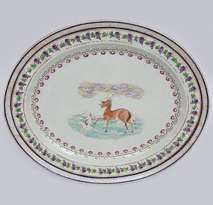 <b>Conselheiro Antônio Prado - João Ferreira Pinto</b> (grande fazendeiro em Minas Gerais) - Grande <B>travessa</b> oval do primeiro serviço do referido nobre, em porcelana Companhia das Índias policromada e decorada ao centro com inspiração nas "fábulas de Esopo", variando o tema de peça para peça. Caldeira decorada com flores e pontilhados. Borda com folhas de videiras e cachos de uvas. Realces a ouro. Circa 1815. Referências bibliográficas à pág. 291 do livro "A Porcelana Chinesa ao Tempo do Império", por Nuno de Castro. Med. 40,5 x 34 cm