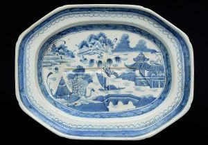 <b>Travessa para assados</b> de forma retangular e cantos chanfrados em porcelana chinesa, dita Macau, decorada em azul índigo "underglaze" com paisagem lacustre, casario e embarcações. Fundo com sulcos em cruz para drenagem de molho. Séc. XVIII. Med. 40,5 x 31,5 cm