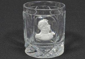 <b>Copo</b> provavelmente da manufatura de VISTA ALEGRE apresentando "sulphide" de D. Pedro I e restante do bojo com gomos em relevo. Séc. XIX. Alt. 9 cm