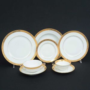 <b>Serviço de jantar </b>em porcelana francesa de <b>LIMOGES</b> decorada por borda a ouro com guirlandas estilizadas. Constando de 12 pratos fundos, 24 pratos rasos, 24 pratos de sobremesa, 12 pratos de pão, 10 taças de "consommé" e 12 xícaras de chá. Nos versos marcas da manufatura. Total de 94 peças.