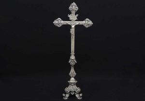 Magnífico <b>crucifixo</b> em prata brasileira do séc. XVIII. Cruz em caneluras com três ponteiras lindamente trabalhadas em "rocailles" barrocos. Haste movimentada decorada com folhas de acanto sobre base trípode de aba gomada e decoração em harmonia ao conjunto. Alt. 89 cm