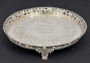 <b>Salva</b> circular em prata portuguesa. Fundo gravado com flores, folhas e monograma ao centro. Galeria vazada com cachos de uvas e folhas de parreira. Triplos pés em garras sob volutas. Marca de ourives da cidade do Porto da segunda metade do séc. XIX, conforme reg. nº 1230 no livro de "Vidal". Diâm. 23 cm. Peso 540 gramas.