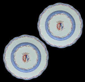 <b>Terceiro Conde de Lumiares</b> (Manoel da Cunha Menezes) - <b>Par de pratos rasos</b> circulares com bordas onduladas em porcelana Companhia das Índias. Ao centro o brasão armorial do referido nobre. Caldeira e aba decoradas com guirlandas e arabescos em azul. Séc. XVIII. Um deles com pequeno restauro. Diâm. 23 cm
