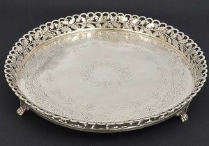 <b>Salva </b>circular em prata portuguesa, apresentando fundo lavrado com folhagens e galeria vazada no mesmo estilo com ondulações. Pés em garras encimadas por volutas. Contraste da cidade do Porto e de ourives de meados do séc. XIX. Diâm. 33,5 cm. Peso 1300 gramas.