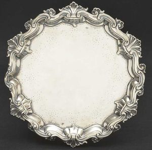 Bela <b>salva</b> circular em prata portuguesa da primeira metade do séc. XVIII. Fundo liso com extremidade em apicoados floridos. Aba movimentada decorada com volutas e concheados. Pés acompanhando o estilo. Marca de ourives de Lisboa, SPJ, da primeira metade do séc. XVIII. Reg. nº 501 no livro de "Vidal". Diâm. 25,5 cm