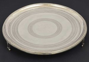 Bela <b>salva</b> circular em prata portuguesa decorada com frisos guilhochados de diversos motivos. Borda em godrões. Triplos pés vazados. Marca da cidade e de ourives do Porto da primeira metade do séc. XIX. Reg. nº 1007 no livro de "Vidal". Diâm. 35,5 cm