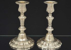 Raríssimo<b> par de castiçais </b>em prata brasileira do início do séc. XVIII. Haste em segmentos de balaústre e decoração com sulcos e filetados. Base movimentada. Sobre a mesma a inscrição: Bahia - Santo Antonio da Mouraria- 5/9/1972 - JM. Sem marcas. Alt. 20 cm