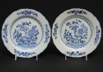 <b>Par de pratos </b>circulares em porcelana Companhia das Índias, apresentam decoração florida em azul índigo "underglaze" e borda levemente movimentada. Séc. XVIII. Diâm. 22,5 cm