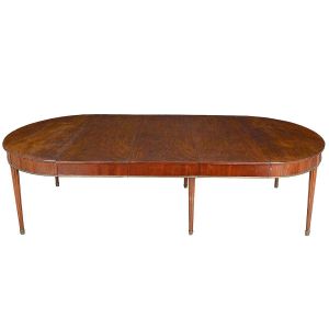 Belíssima e extensa <b>mesa de jantar</b> francesa Louis XVI construída em madeiras nobres europeias. Tampo de forma retangular com extremidades arredondadas apresentando em cada, uma gaveta. Saia lisa com aba decorada por friso metálico. Seis pernas cilíndricas torneadas levemente afiladas e entalhadas com frisos. Pés em ponteiras. Encaixes internos em traves corrediças de carvalho. Apresenta vestígios de selo da cidade de Paris. Alt. 75 cm; Med. aberta com todas as 4 tábuas extensoras 320 cm; Larg. 165 cm; Compr. fechada 122 cm; Larg. de cada tábua 50 cm