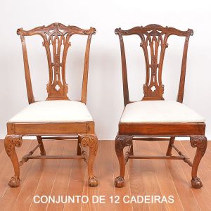 <b>Conjunto de 12 cadeiras</b> construídas em madeiras nobres. Encostos com entalhes vazados decorados com volutas nas extremidades. Assentos forrados em tecido creme. Pernas levemente recurvadas com joelheiras entalhadas terminadas em pés de garras sobre bolas. Séc. XIX. Alt. 100 cm