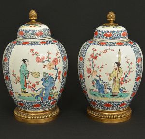 <b>Par de potiches</b> bojudos em porcelana chinesa do início do séc. XIX apresentando cartuchos decorados com paisagens com figuras em policromia. Base e pega da tampa em bronze. No interior selo do antiquário de Lyon. Alt. 28 cm