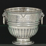 <b>Balde para gelo </b>em prata portuguesa, decorado com lavrados floridos, gomos em baixo relevo e alças modeladas em cabeças de leões com argolas. Interior com escoador. Contraste da cidade do Porto usado a partir de 1938. Teor 833 ml e marca de prateiro. Peso 690 gramas. Alt. 13,5 cm
