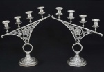 <B>Par de candelabros</b> (hanukkah menorah), em prata holandesa, cada qual para quatro velas, com receptáculos perolados dispostos em aclive e decoração com flores e estilizações vegetais tendo ao centro pequena estrela de David. Base abobadada. Contraste usado a partir de 1953 e marca de prateiro. Alt. 51 cm. Peso 2600 gramas.