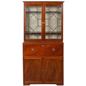 Belíssimo <b>móvel inglês</b> vitoriano conhecido como "secretaire-cabinet" construído em mogno. Parte superior em armário vitrine com duas portas envidraçadas. Gavetão central rebatível forrado em couro de época e interior com escritório decorado com diversos escaninhos, gavetinhas e cofre ao centro, apresentando "marqueterie" de um caramujo. Parte inferior em armário com interior apresentando duas gavetas na parte baixa. Ferragens de época. Inglaterra. Primeira metade do séc. XIX. Med. fechado 202 x 106 x 51 cm