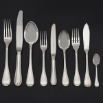 <b>MAISON CHRISTOFLE - Faqueiro</b> em metal espessurado a prata, modelo "Rubans" apresentando cabos filetados com cruzetas e terminados em lacinho. Marca da orfèvrerie em todas as peças. Constando de 12 garfos de mesa, 12 facas de mesa, 12 garfos para peixe, 12 facas para peixe, 12 garfos para sobremesa, 12 facas para sobremesa, 12 colheres para sobremesa, 12 colheres para café e 6 peças de servir. Lâminas em perfeito estado. Faqueiro praticamente sem uso. Total de 102 peças.