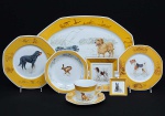 <b>MAISON HERMÈS </b>- Paris. <b>Conjunto para jantar</b> em porcelana policromada decorada com animais. Constando de 6 pratos rasos, 6 pratos fundos, 6 pratos de sobremesa, 6 grandes xícaras com pires para chocolate, 1 travessa redonda p/ arroz (32 cm), 1 travessa retangular chanfrada, 1 cinzeiro e 1 pequeno covilhete quadrado. Total de 28 peças. Compr. da travessa 47,5 cm; Med. do prato raso 25,5 cm