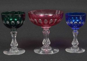 Belíssimo<b> conjunto de copos em cristal BACCARAT </b>lapidado em elementos ovais composto por 33 taças para champanhe na cor rubi, 12 taças para licor na cor verde e 6 taças para Porto na cor azul cobalto. Alt. 11 e 10,5 cm