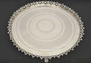 Grande e bela <b>salva</b> em prata portuguesa de forma circular. Centro gravado com círculos texturizados. Galeria vazada e decorada com angras centralizando folhas de acanto. Cinco pés no estilo. Marca da cidade e de ourives do Porto do terceiro quartel do séc. XIX. Reg. nº 1445 no livro de "Vidal". Diâm. 55,5 cm. Peso 3070 gramas.