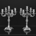 <b>Par de candelabros</b> para cinco velas em prata portuguesa lavrada e cinzelada com volutas, elementos concheados e folhas de acanto. Contraste da cidade do Porto usado a partir de 1938 e marca de prateiro. Teor 833 ml. Peso 3000 gramas. Alt. 36,5 cm
