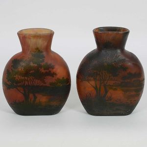 <b>DAUM NANCY - Par de vasos</b> em pasta de vidro acidado trabalhado em cameo decorados com paisagens lacustres em tonalidades de vermelho, amarelo e laranja. Assinados na parte inferior. Alt. 19,5 cm; Larg. 15 cm