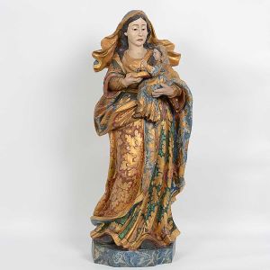 Grande imagem brasileira de <b>SantAna, com a Virgem Maria</b>, em madeira, com bela policromia de flores e volutas realçadas a ouro. SantAna encontra-se de pé com a Virgem protegida em seu braço, com o evangelho. Veste e manto entalhados em pregueados e espraiados aos pés. Pano de cabeça esvoaçante entrevendo-se parte do cabelo. Base marmorizada. Séc. XIX. Alt. 93 cm