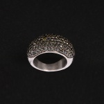 <b>Anel</b> em ouro branco 18k, abaulado, cravejado com brilhantes negros. Peso 6,3 gramas.