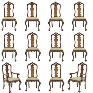 Antigo conjunto de <b>12 cadeiras</b> brasileiras no estilo D. José I, em madeira nobre, sendo 2 com braços. Tabela em recortes e vazados "rocailles" com saia rasa e pernas recurvas entalhadas, terminadas em garras sobre esferas. Assento em linhão. Alt. 115 cm